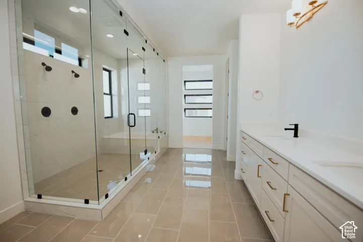 Spacious bathroom featuring a large glass-enclosed shower with multiple showerheads, a built-in shower bench, and a separate soaking tub