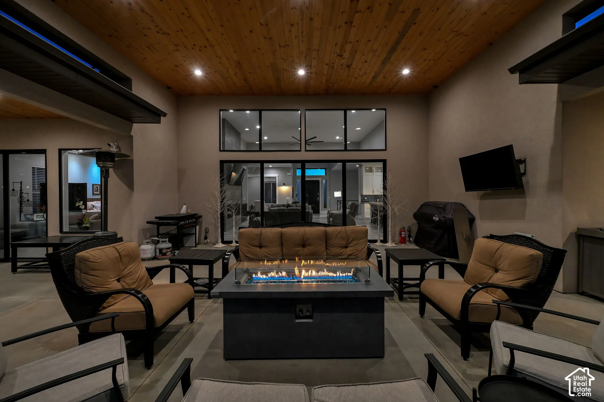 Covered patio with a wood plank ceiling, and recessed lighting.