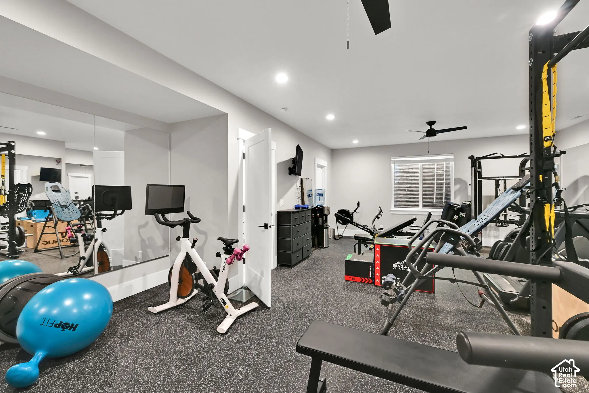 Dedicated fitness space featuring rubber flooring, recessed lighting, and a ceiling fan. Can easily be converted to 6th bedroom.