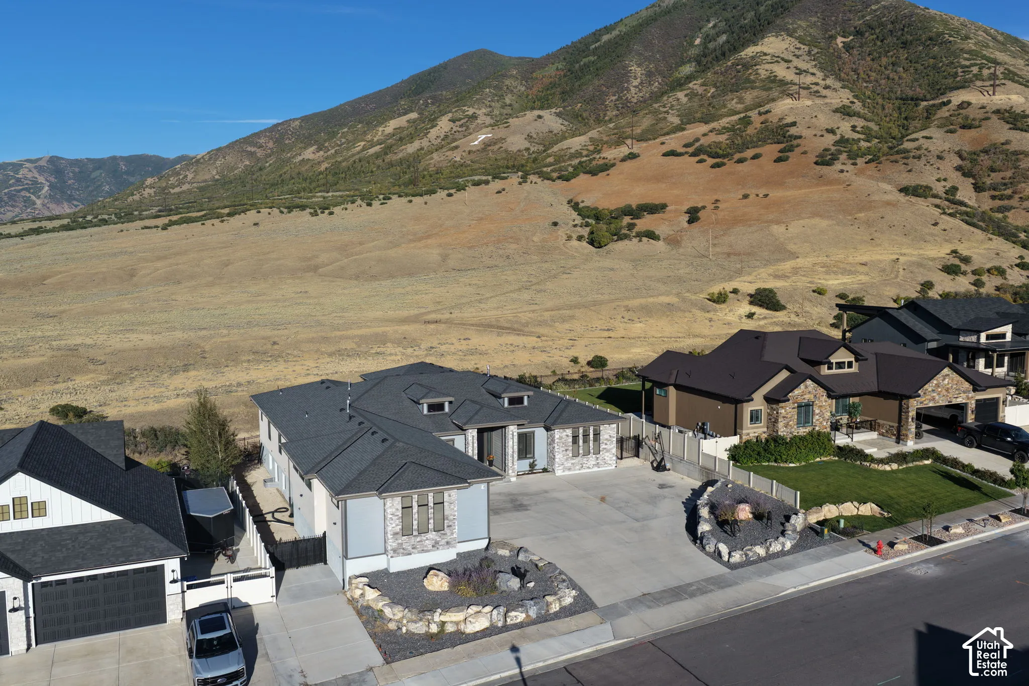 Modern dwelling featuring a stone and siding exterior, multi-gabled roof, and driveway.