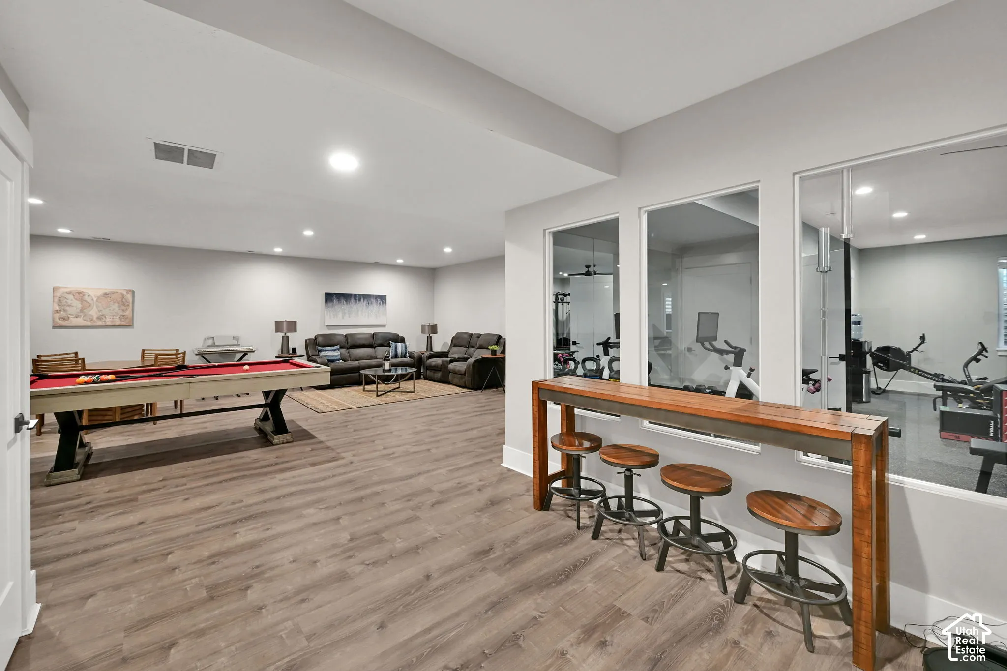 Spacious lower-level area featuring recessed lighting, wood-finish flooring.