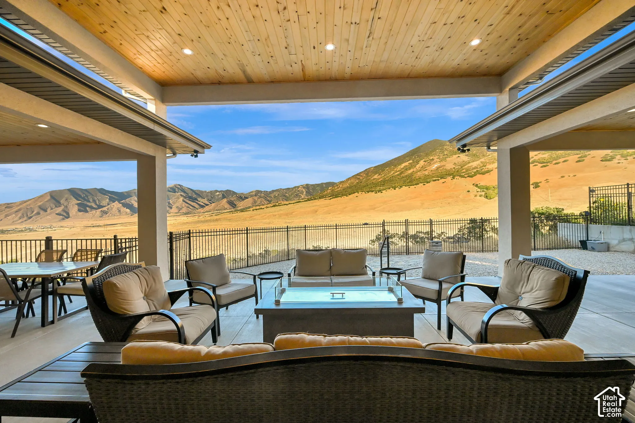 Expansive covered patio with a natural wood plank ceiling, recessed lighting, and a durable concrete floor