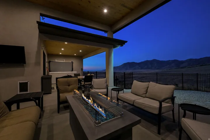 Covered patio featuring a built-in fire pit, recessed lighting, wood-finish ceiling, and mountain scenery