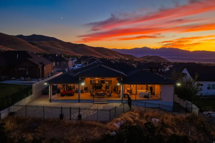 Expansive covered patio with recessed lighting, stone paver flooring, and a built-in hot tub