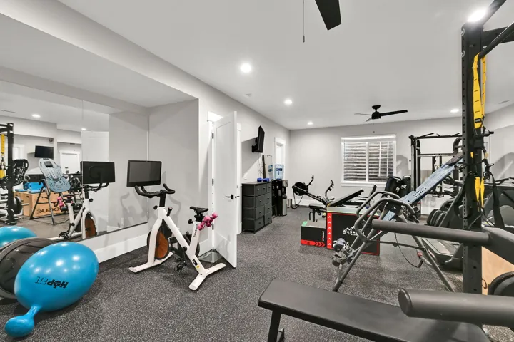 Dedicated fitness space featuring rubber flooring, recessed lighting, and a ceiling fan