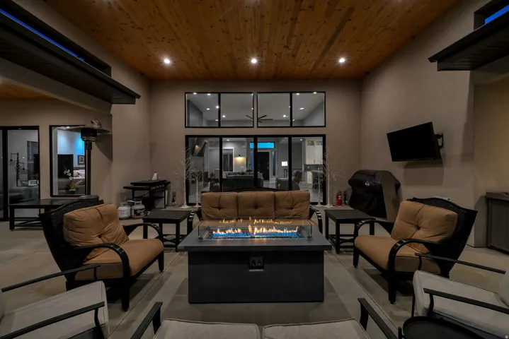 Covered patio with a wood plank ceiling, recessed lighting, and a built-in fire pit