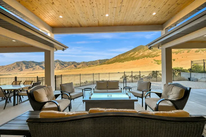 Expansive covered patio with a natural wood plank ceiling, recessed lighting, and a durable concrete floor
