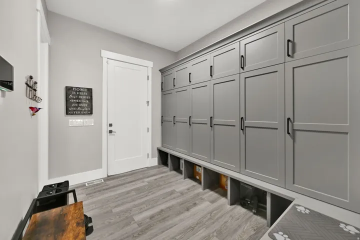 Built-in cabinetry with matte black hardware, wood-finish flooring, and white trim