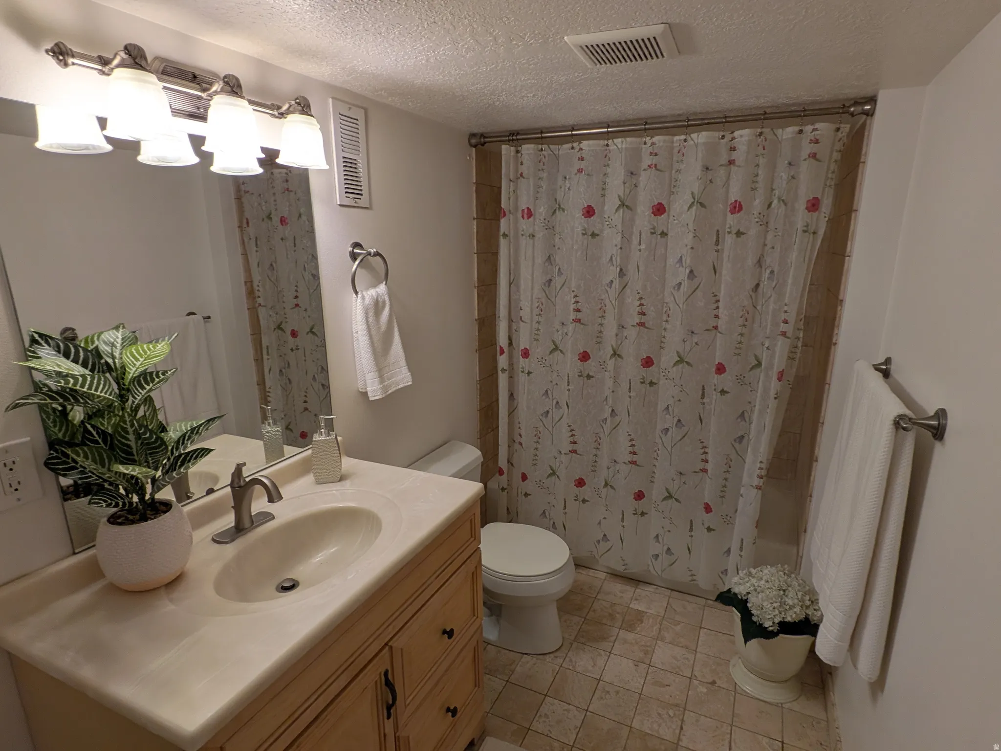 Single vanity with integrated sink, brushed nickel faucet, and wood-finish cabinetry
