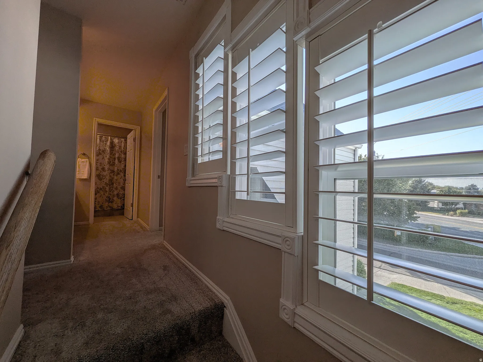 Hallway with carpeting and neutral wall paint