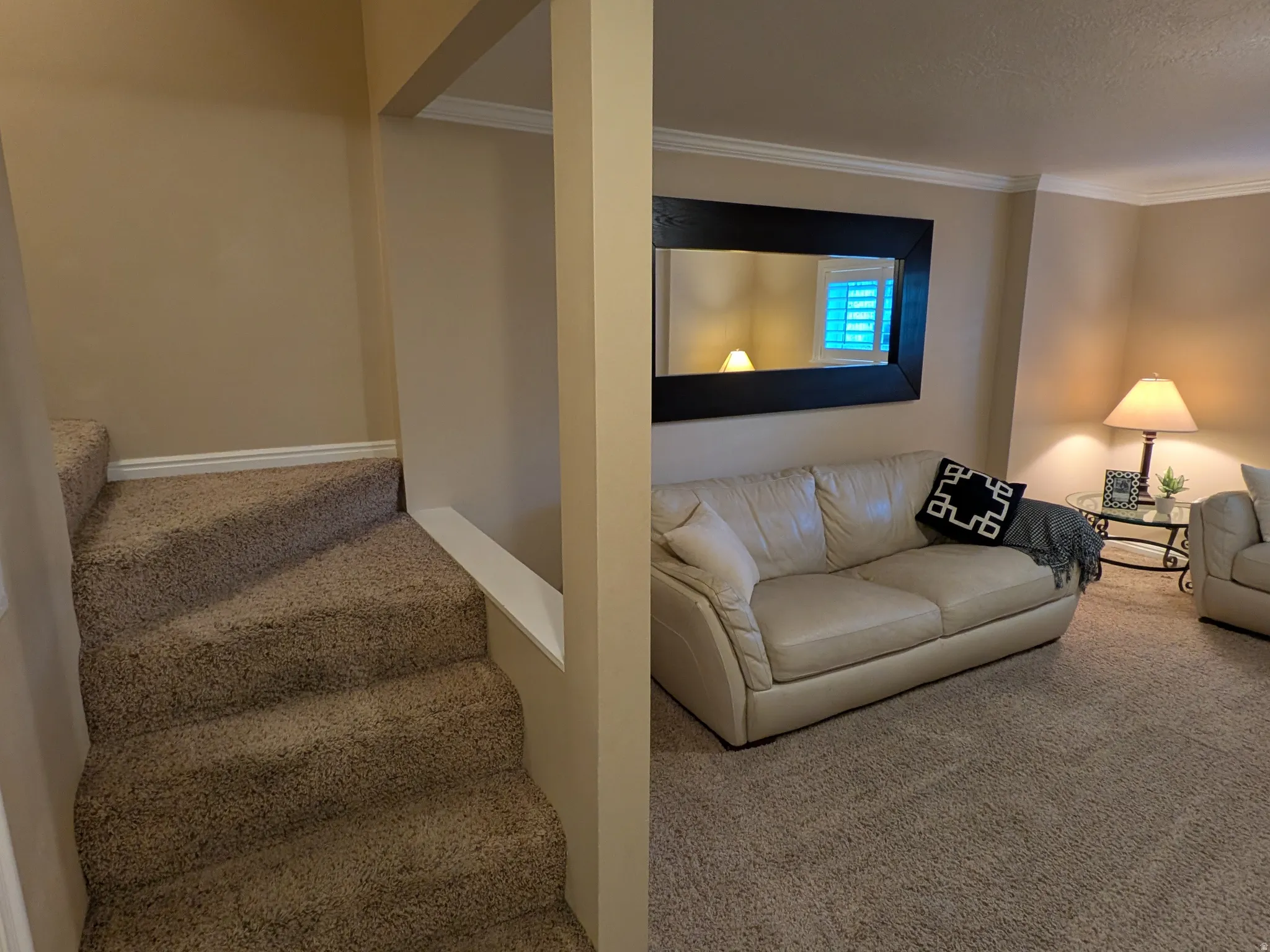 Carpeted staircase leading to a landing with a half-wall and crown molding