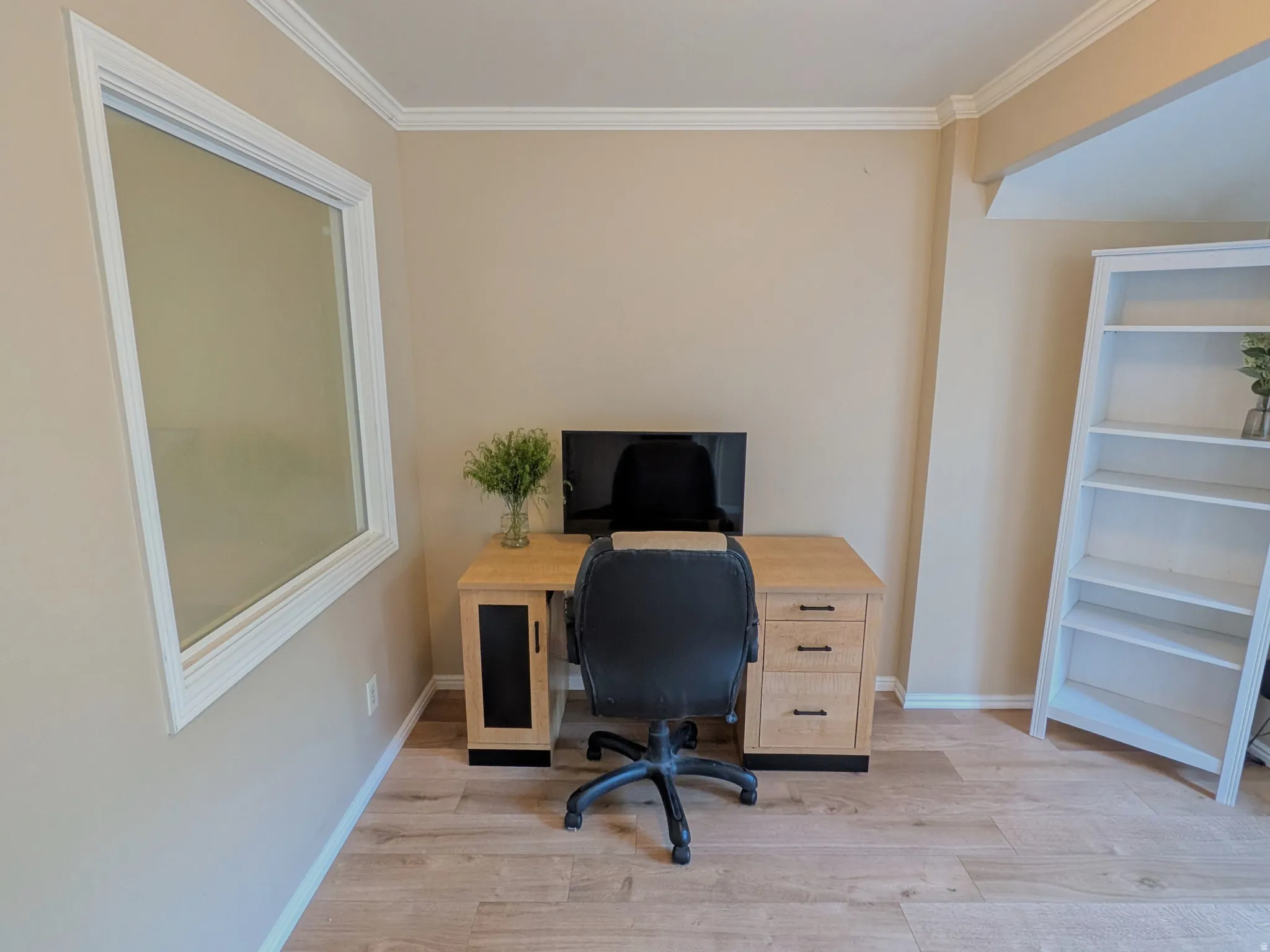 Crown molding, wood-finish flooring, and light-toned wall paint