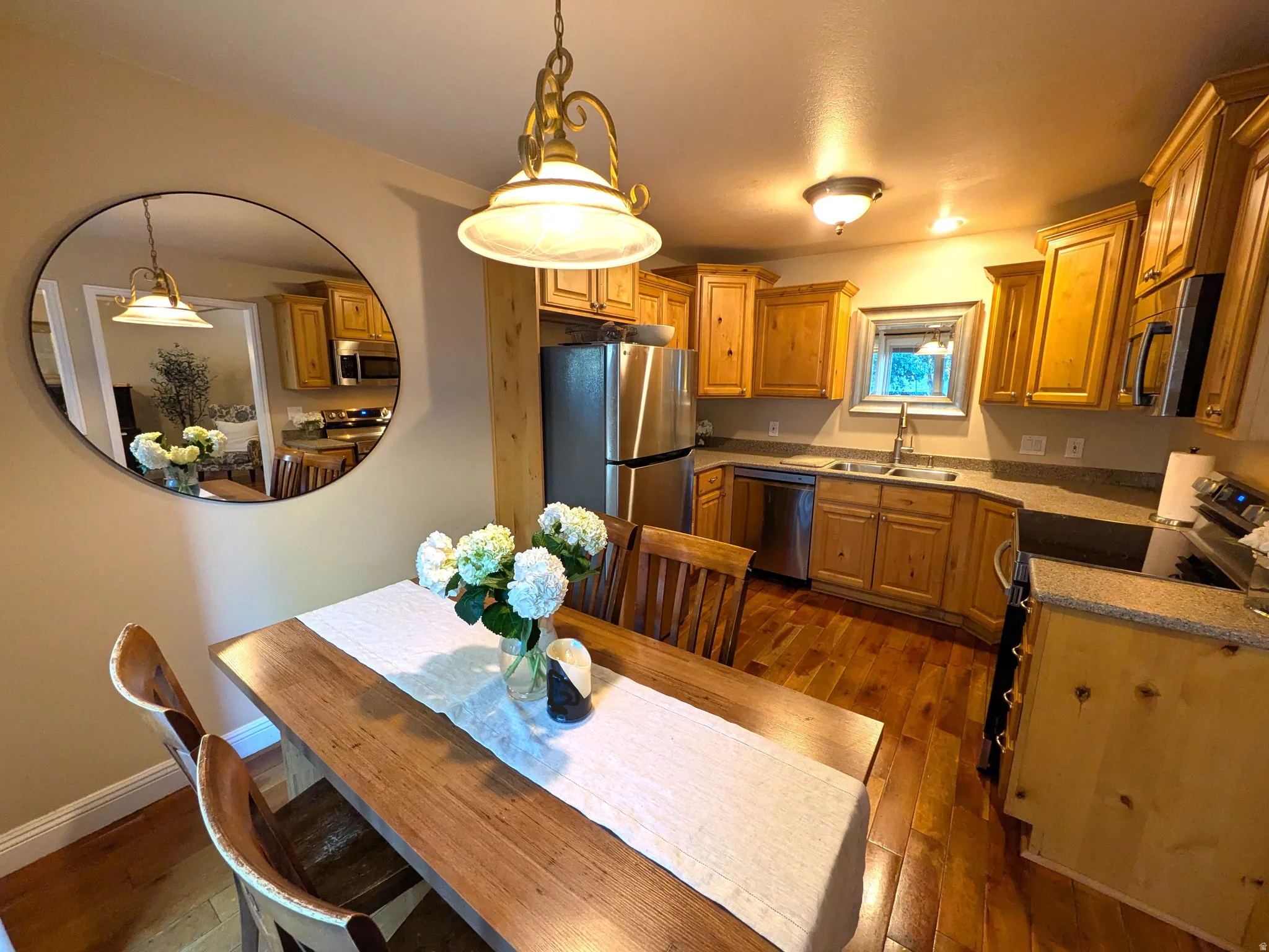 Hardwood flooring, recessed lighting, wood cabinetry, stainless steel appliances, and a double basin sink