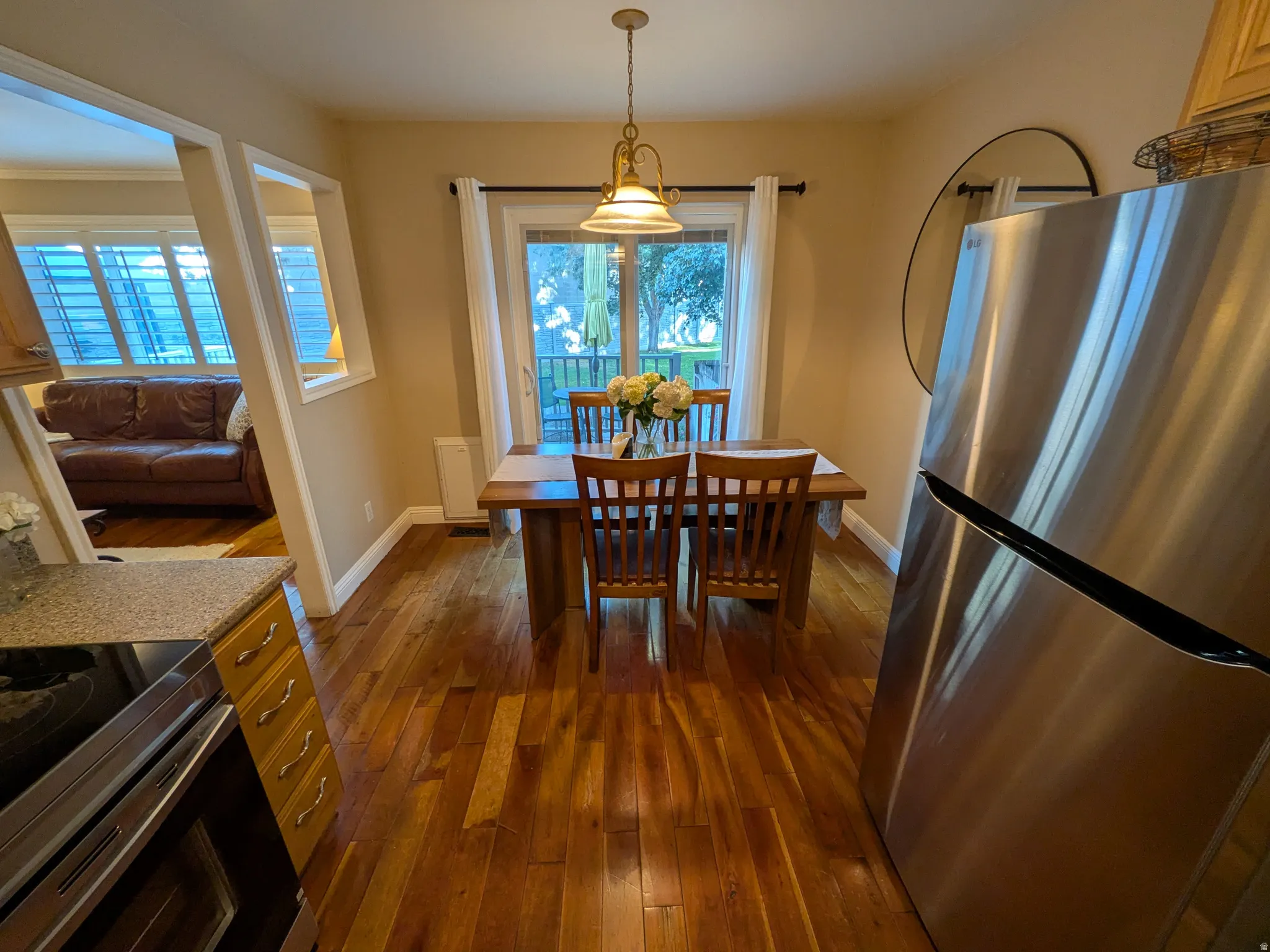 Hardwood flooring, stainless steel refrigerator, glass-paneled sliding door, recessed wall opening, and electric range