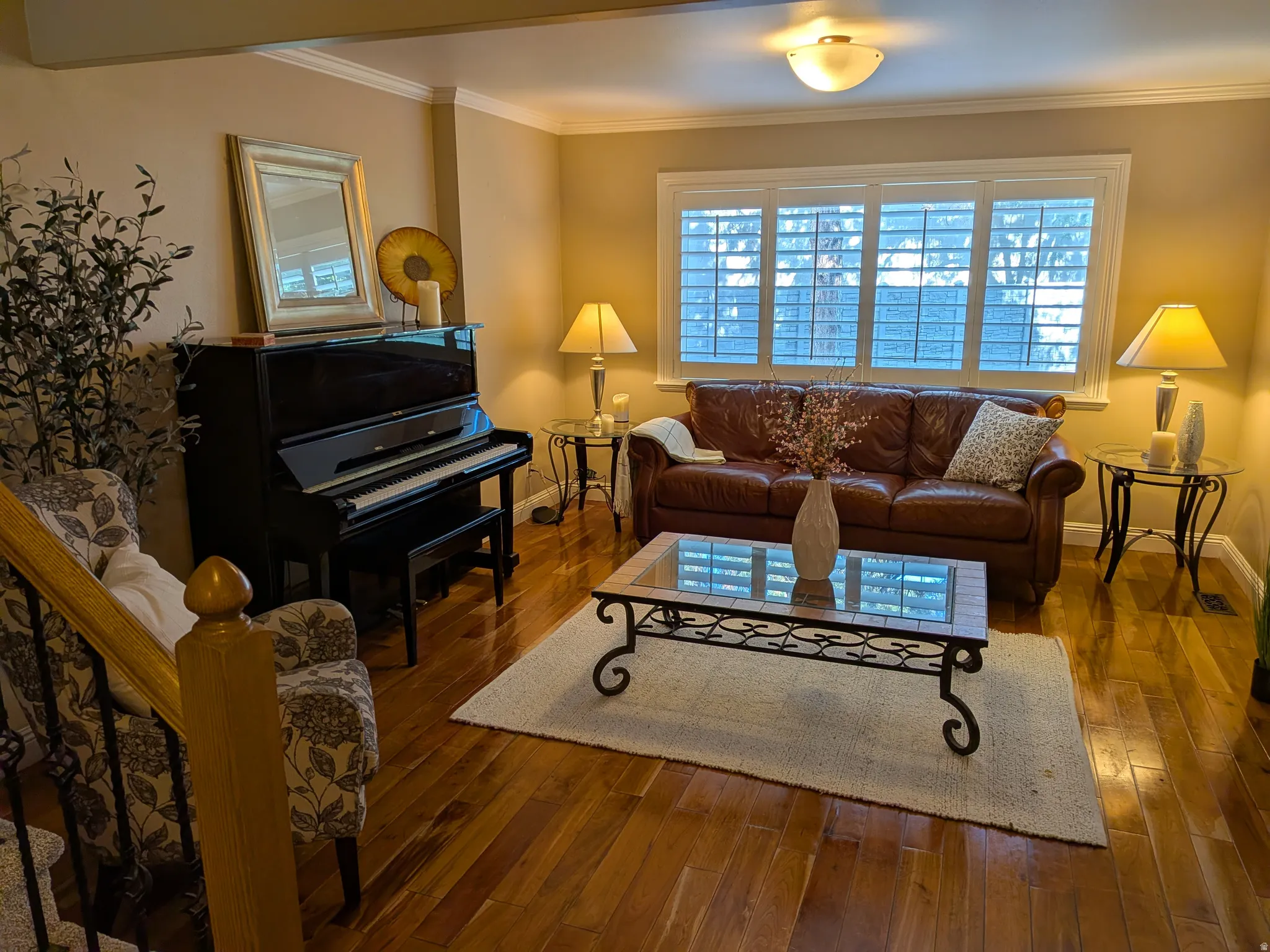 Hardwood flooring, crown molding, and a built-in window with plantation shutters
