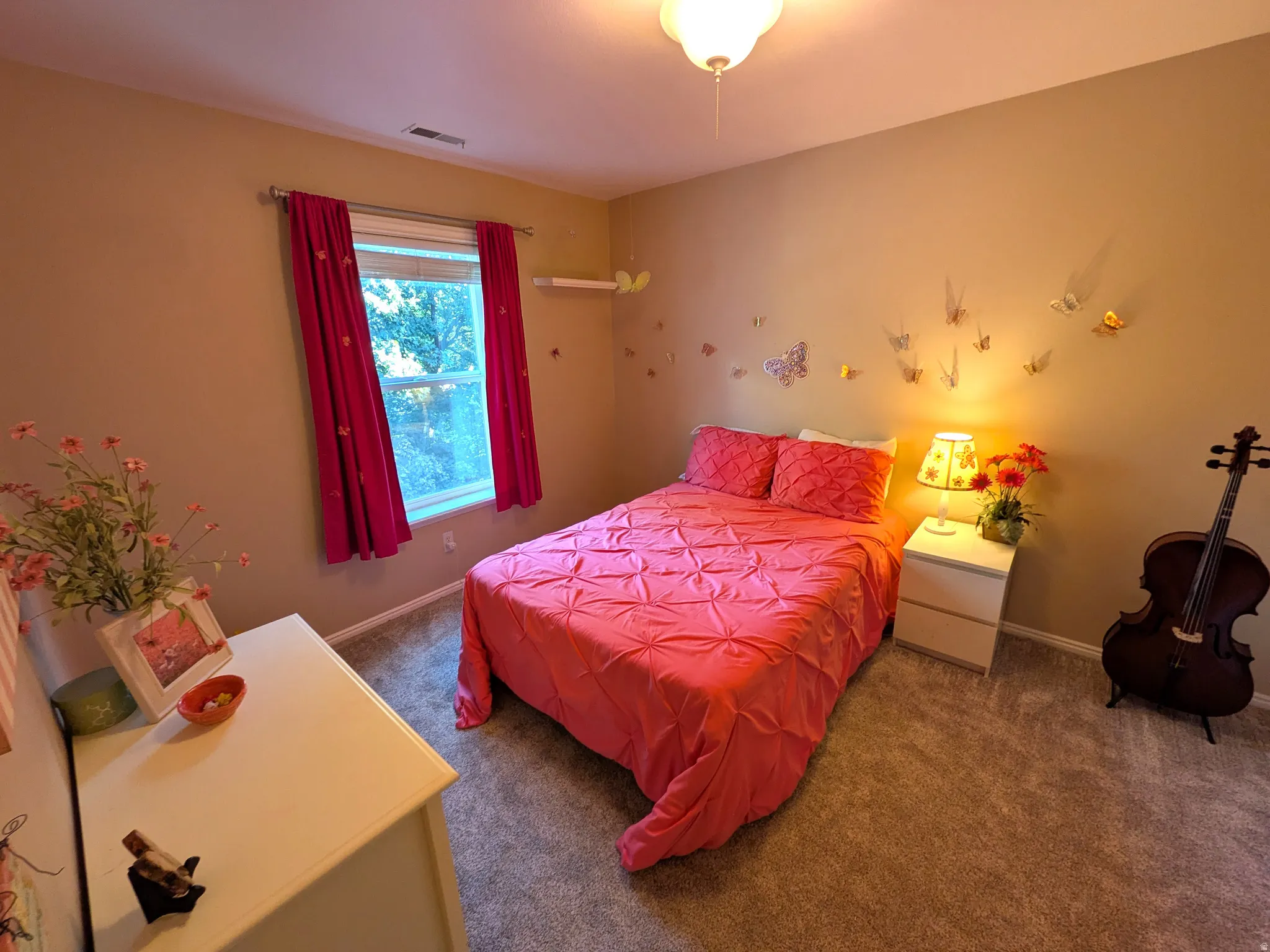 Neutral wall tones, window with vertical blinds, textured carpeting, and ceiling-mounted light fixture