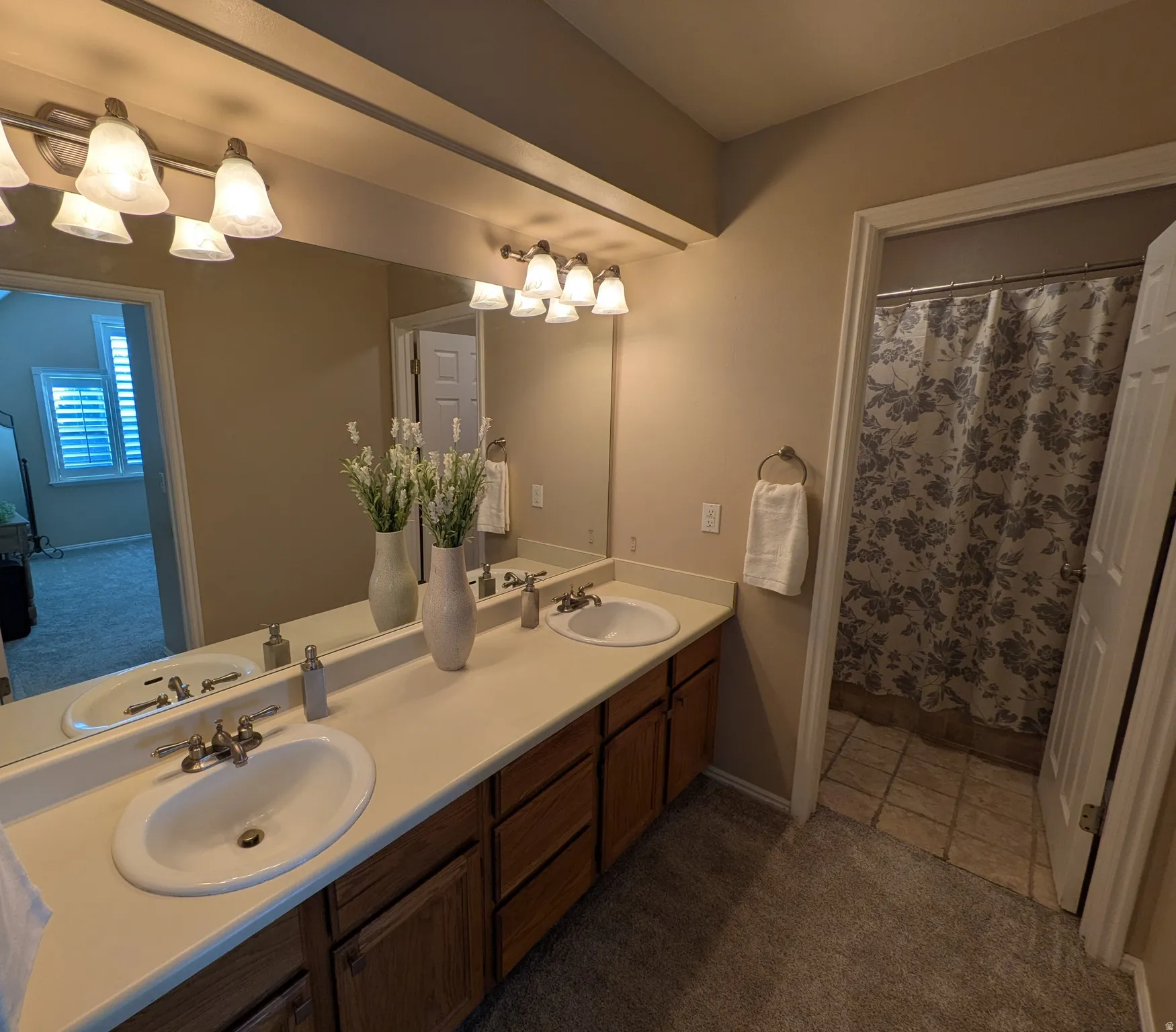 Dual vanity with integrated sinks, wood-finish cabinetry, and a full-width mirror