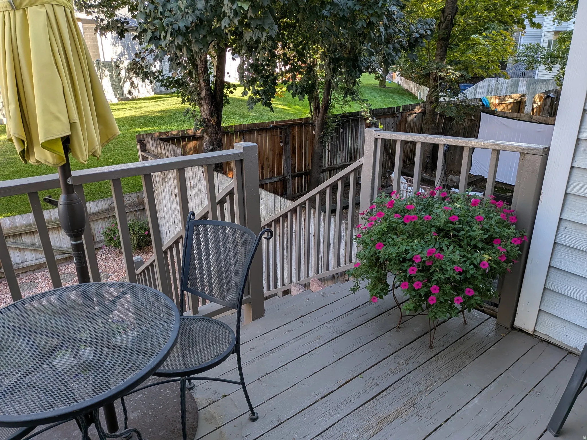 Wooden deck with a painted finish, featuring a full railing system and stairs leading to a lower level