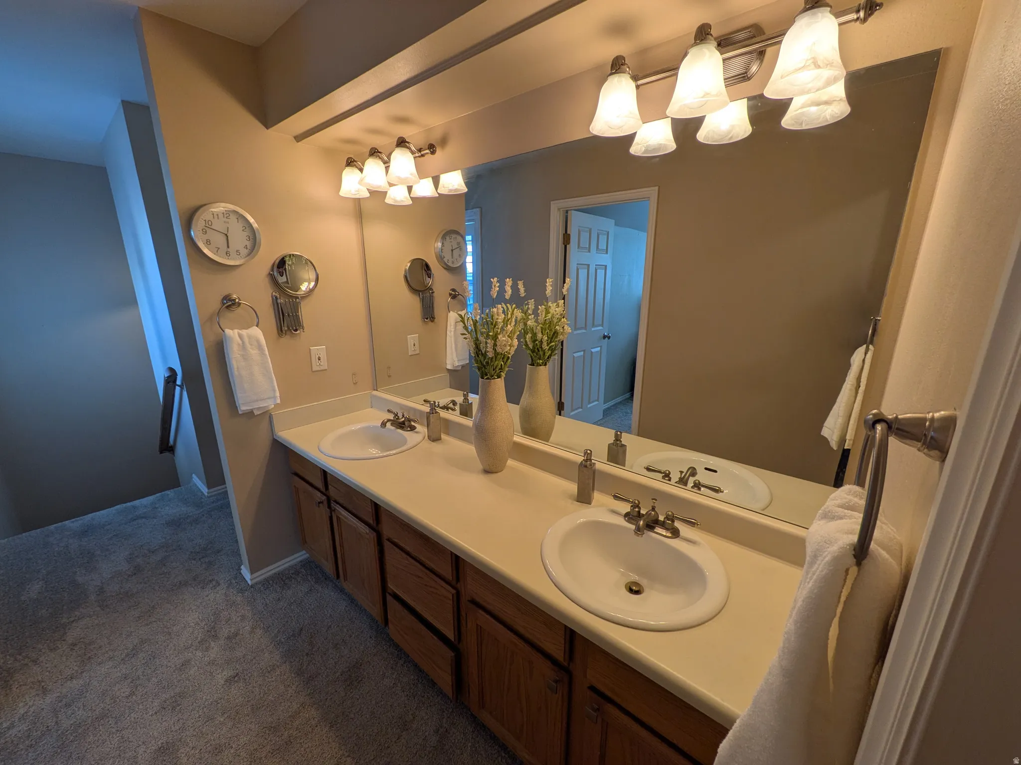 Double vanity with oval sinks, laminate countertop, and wood-finish cabinetry