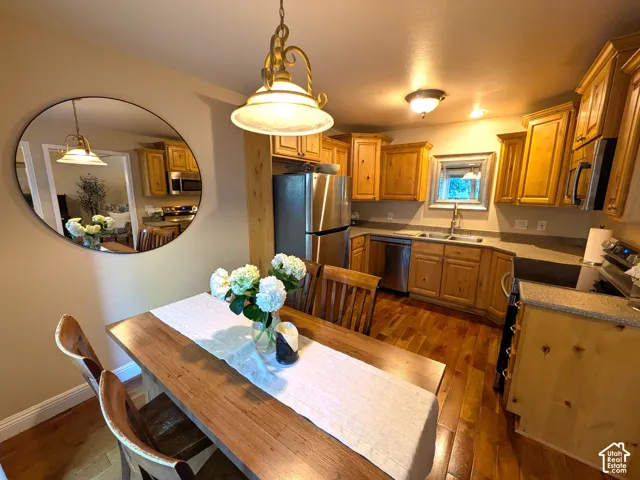 Hardwood flooring, recessed lighting, wood cabinetry, stainless steel appliances, and a double basin sink