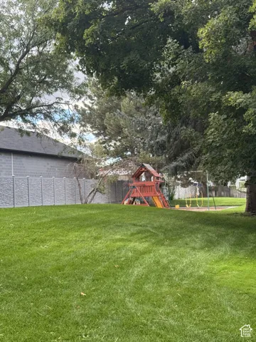 Expansive lawn with mature trees and a privacy fence