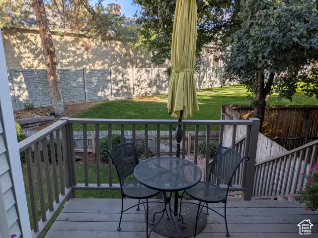 Wooden deck with railing leading to a graded lawn
