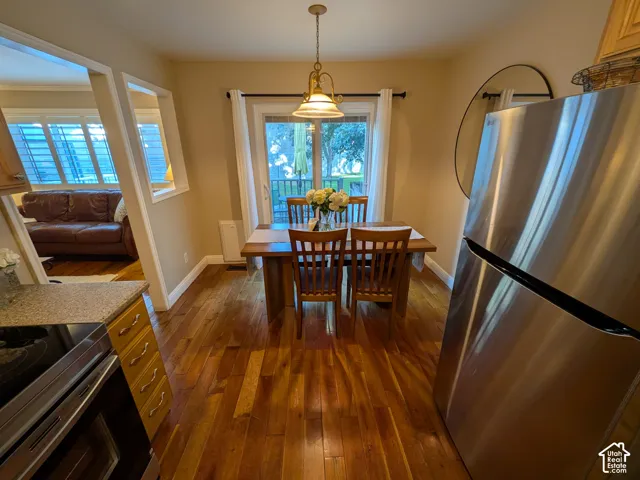 Hardwood flooring, stainless steel refrigerator, glass-paneled sliding door, recessed wall opening, and electric range