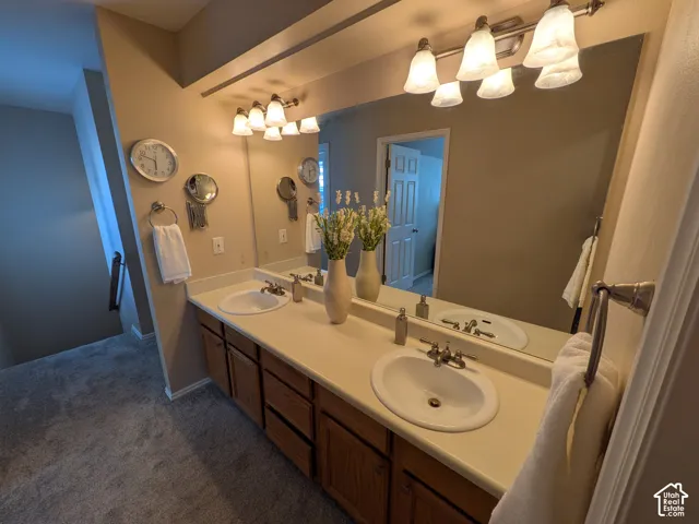 Double vanity with oval sinks, laminate countertop, and wood-finish cabinetry