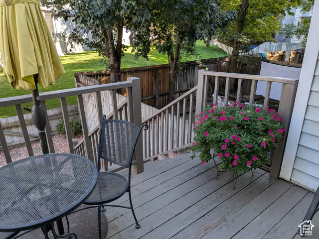 Wooden deck with a painted finish, featuring a full railing system and stairs leading to a lower level