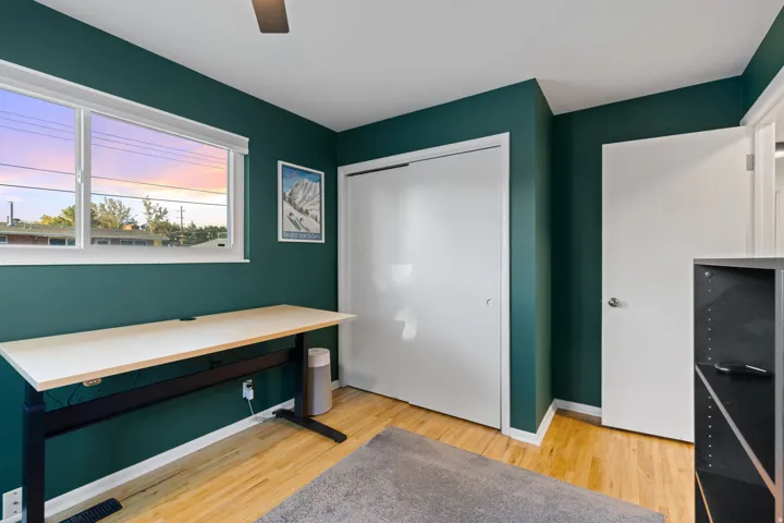 Hardwood-style flooring, white trim, and a window with blinds