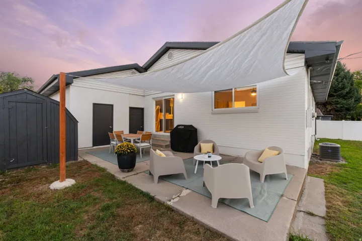 Expansive concrete patio with a shade sail, providing an outdoor living area