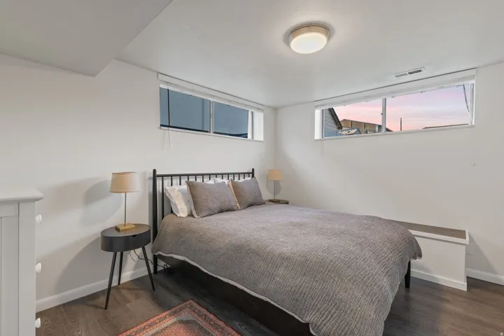 Recessed windows with blinds, wood-finish flooring, and flush mount ceiling lighting