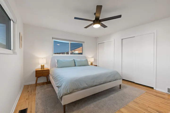 Wood-finish flooring throughout, complemented by a contemporary ceiling fan