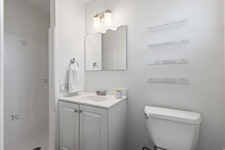 White vanity with an integrated sink, polished chrome faucet, and mirrored medicine cabinet
