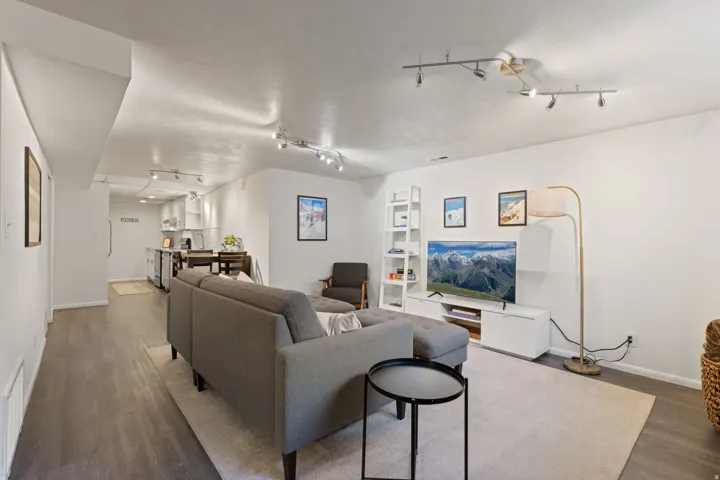 Open-concept living space featuring wood-finish flooring, recessed lighting, and track lighting