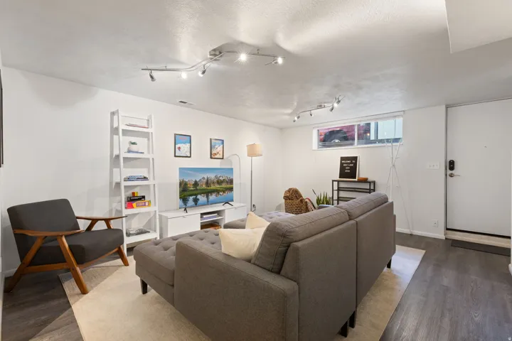 Wood-finish flooring throughout, white walls, a track lighting system, and a transom window