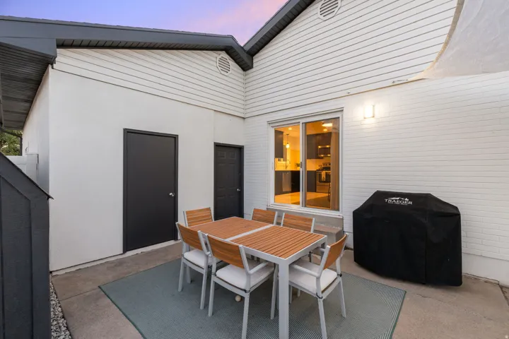 Private patio with concrete flooring, white exterior siding, and a sliding glass door