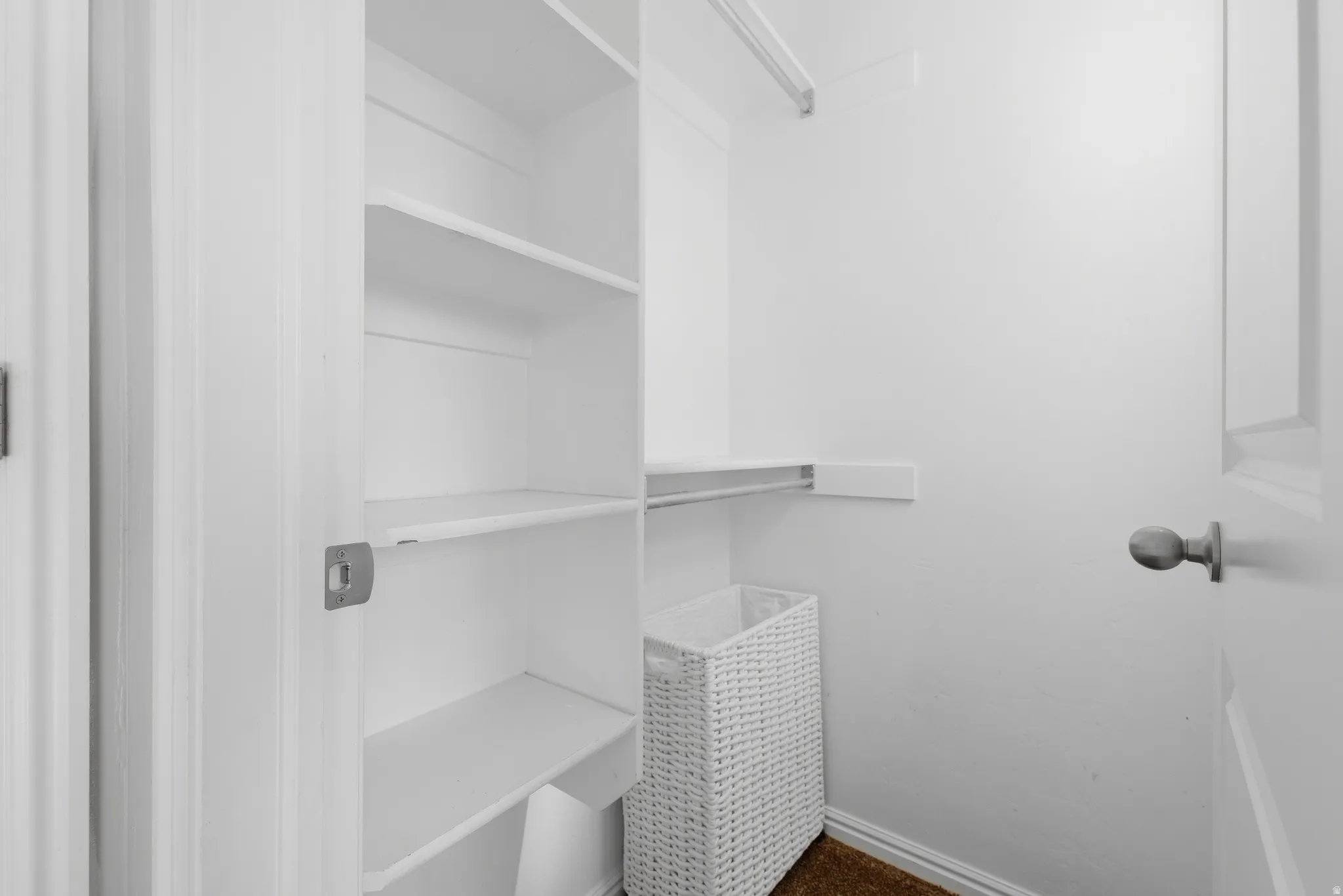 Built-in shelving and a clothing rod provide organized storage within this closet