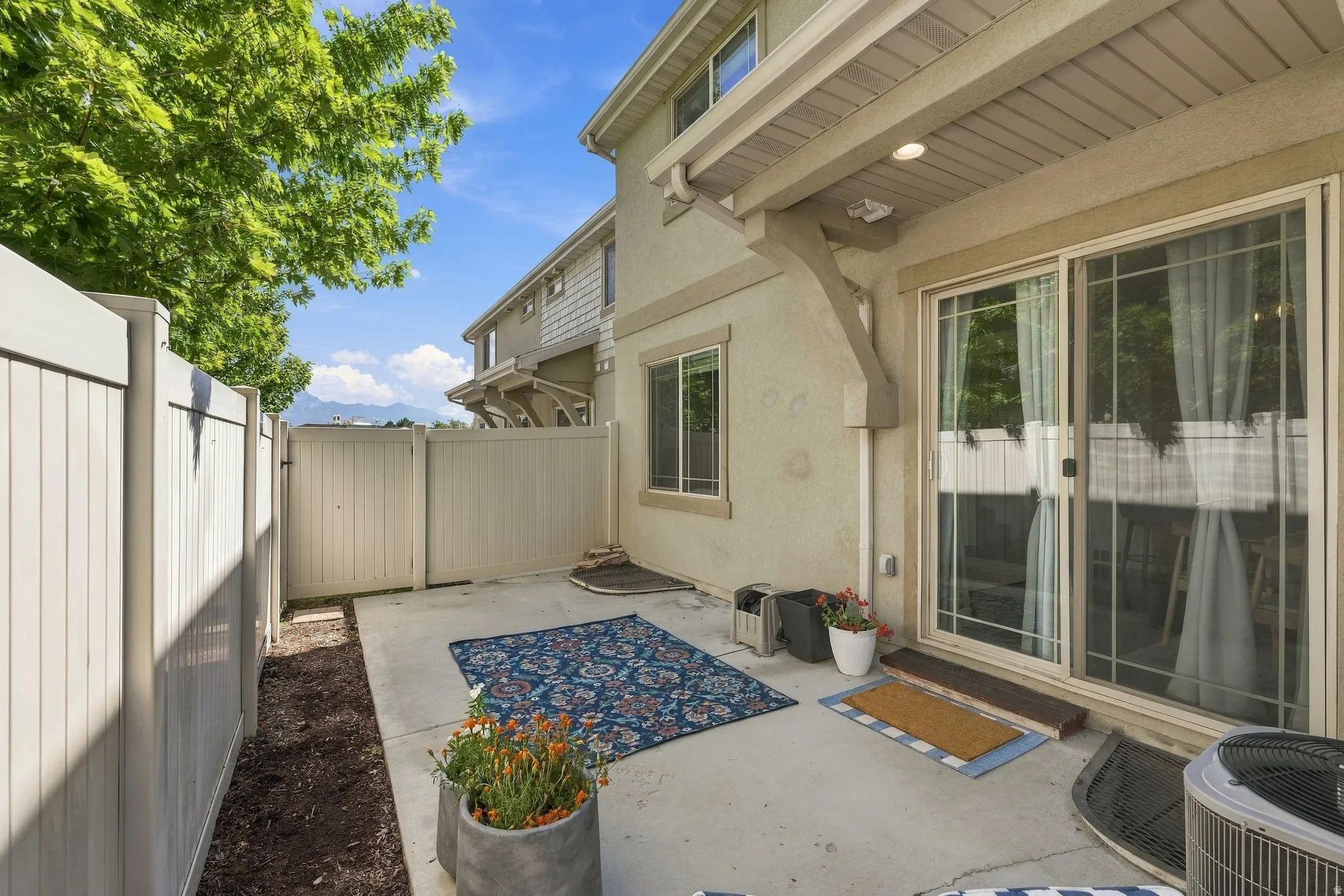 Private outdoor patio featuring a concrete surface and a vinyl privacy fence