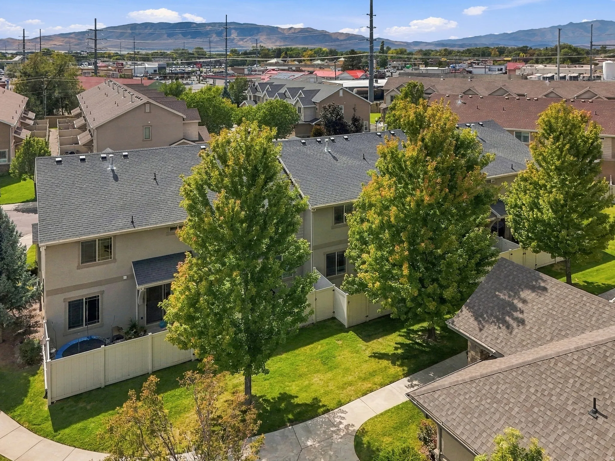 Rear exterior featuring a patio, private fencing, and mature trees