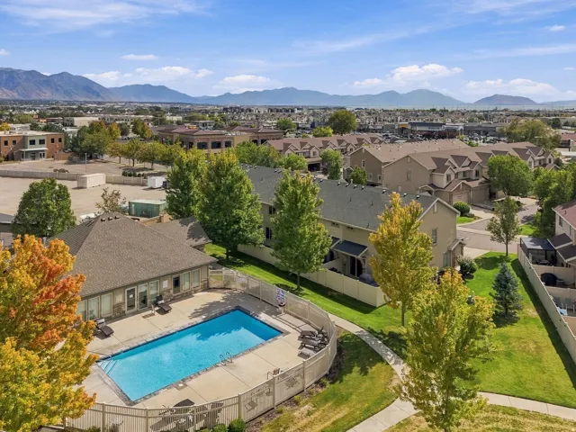 Community swimming pool with surrounding fence and paved pathways
