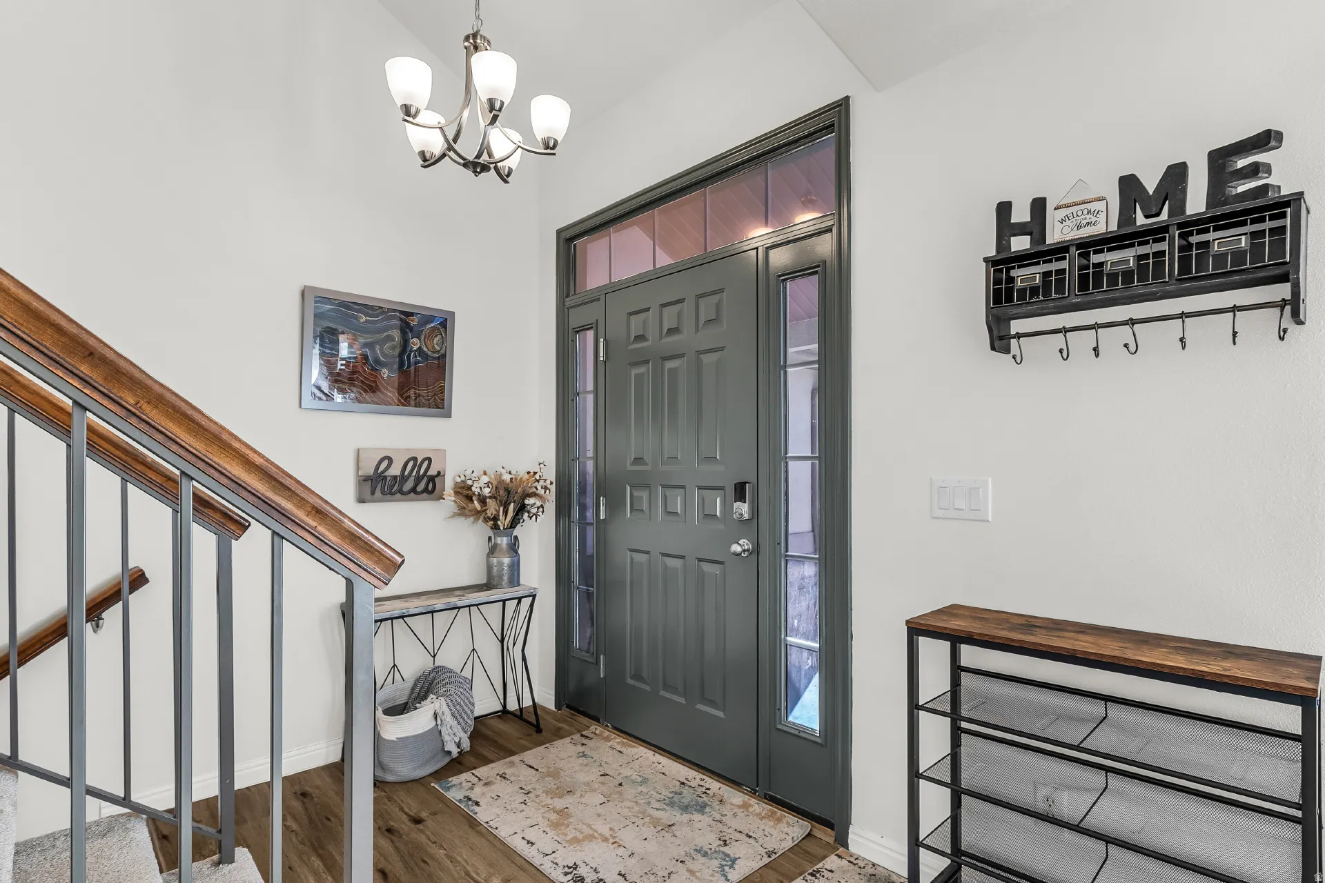 Entry door with side lite and transom window, updated LVP flooring and contemporary chandelier.