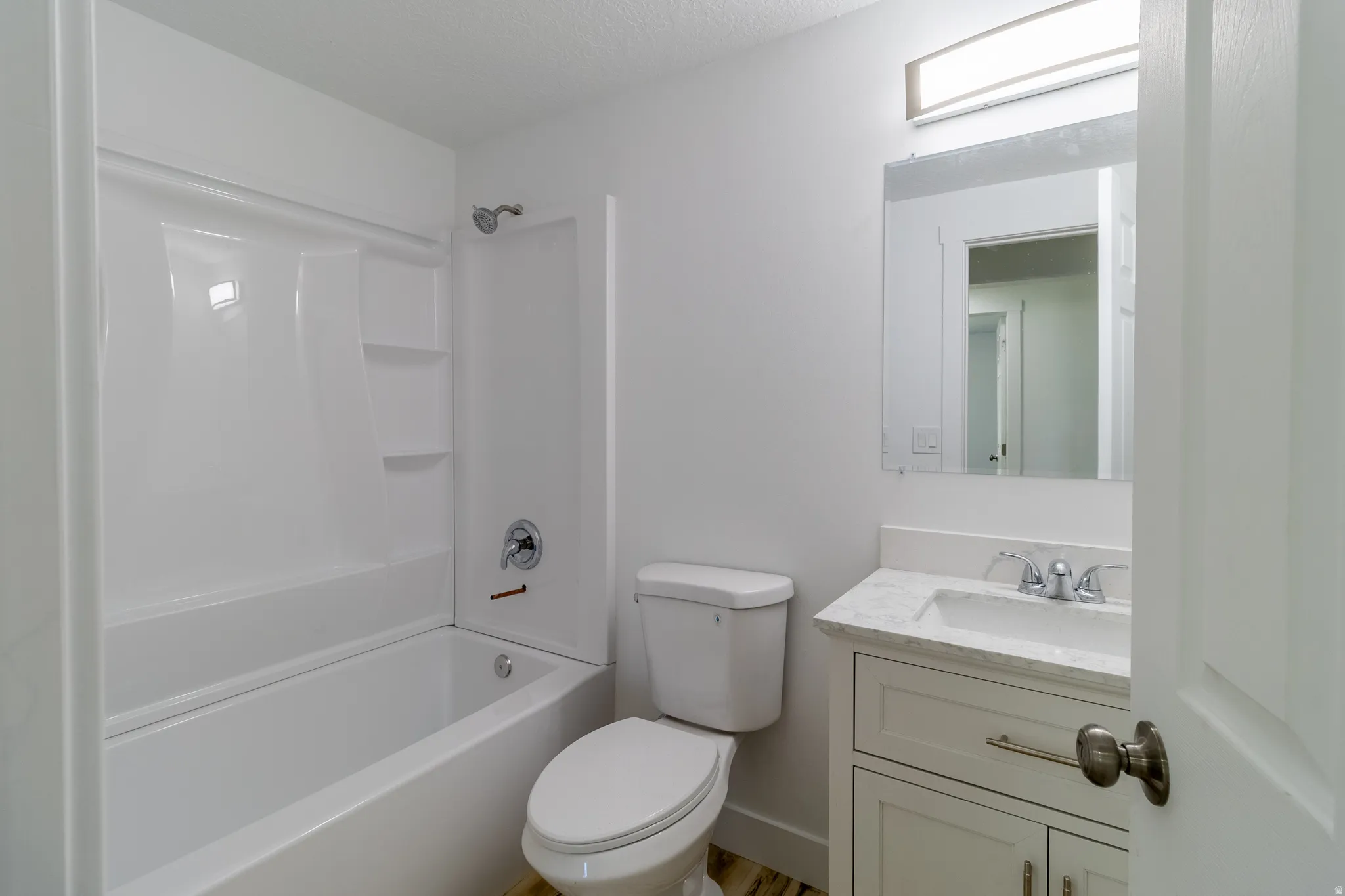 White tub and shower combination with integrated shelving