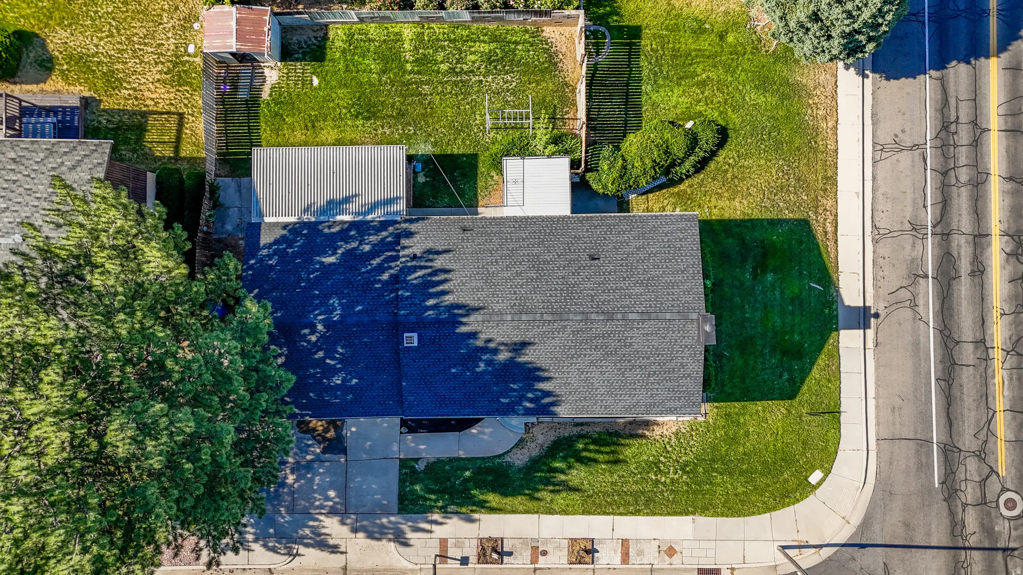 Asphalt shingle roofing over the main structure, with a flat roof covering an attached structure