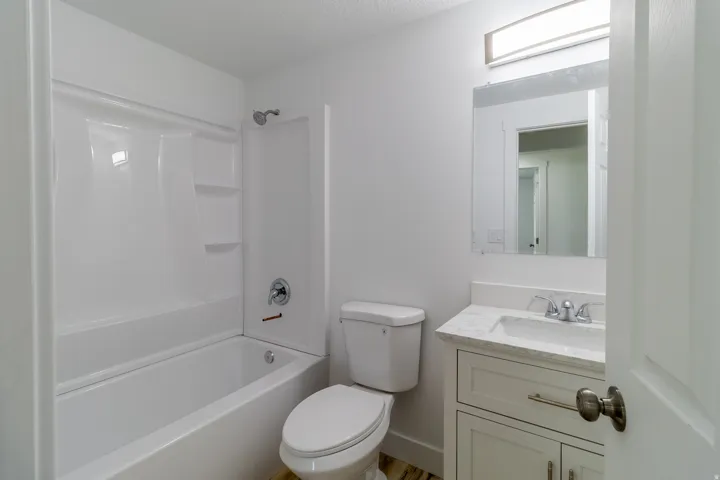 White tub and shower combination with integrated shelving