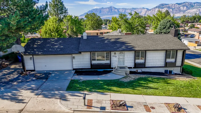 Single-story residence featuring a two-car garage, front lawn, and paved driveway
