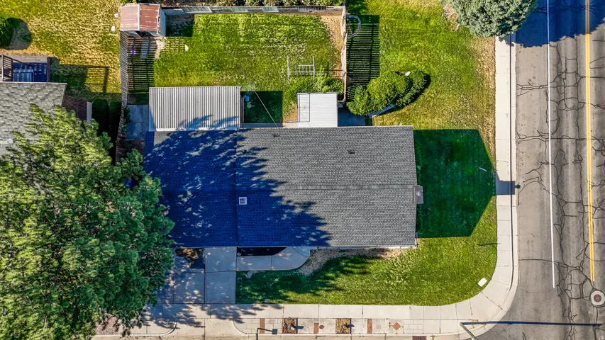 Asphalt shingle roofing over the main structure, with a flat roof covering an attached structure