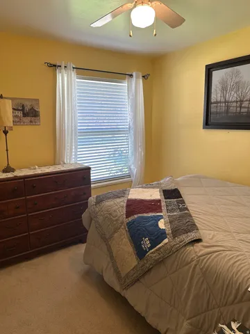 Carpeted flooring, window with blinds, and ceiling fan with integrated lighting