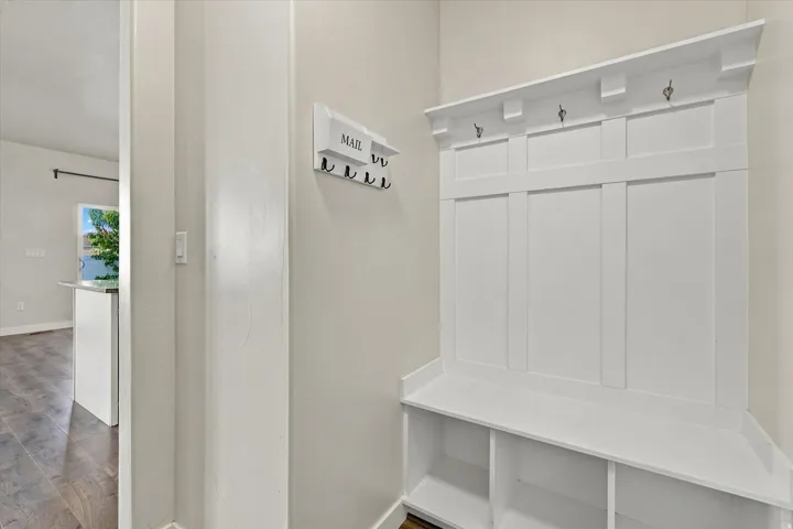 Built-in white mudroom bench with storage cubbies and coat hooks