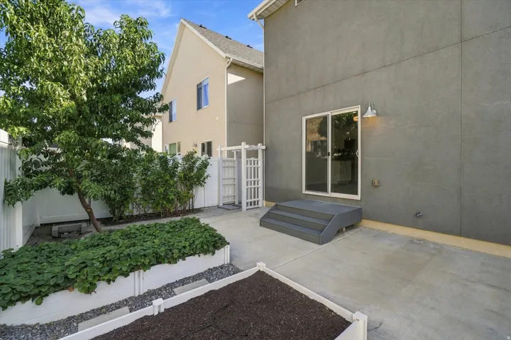 Concrete patio with a sliding glass door and exterior wall sconce